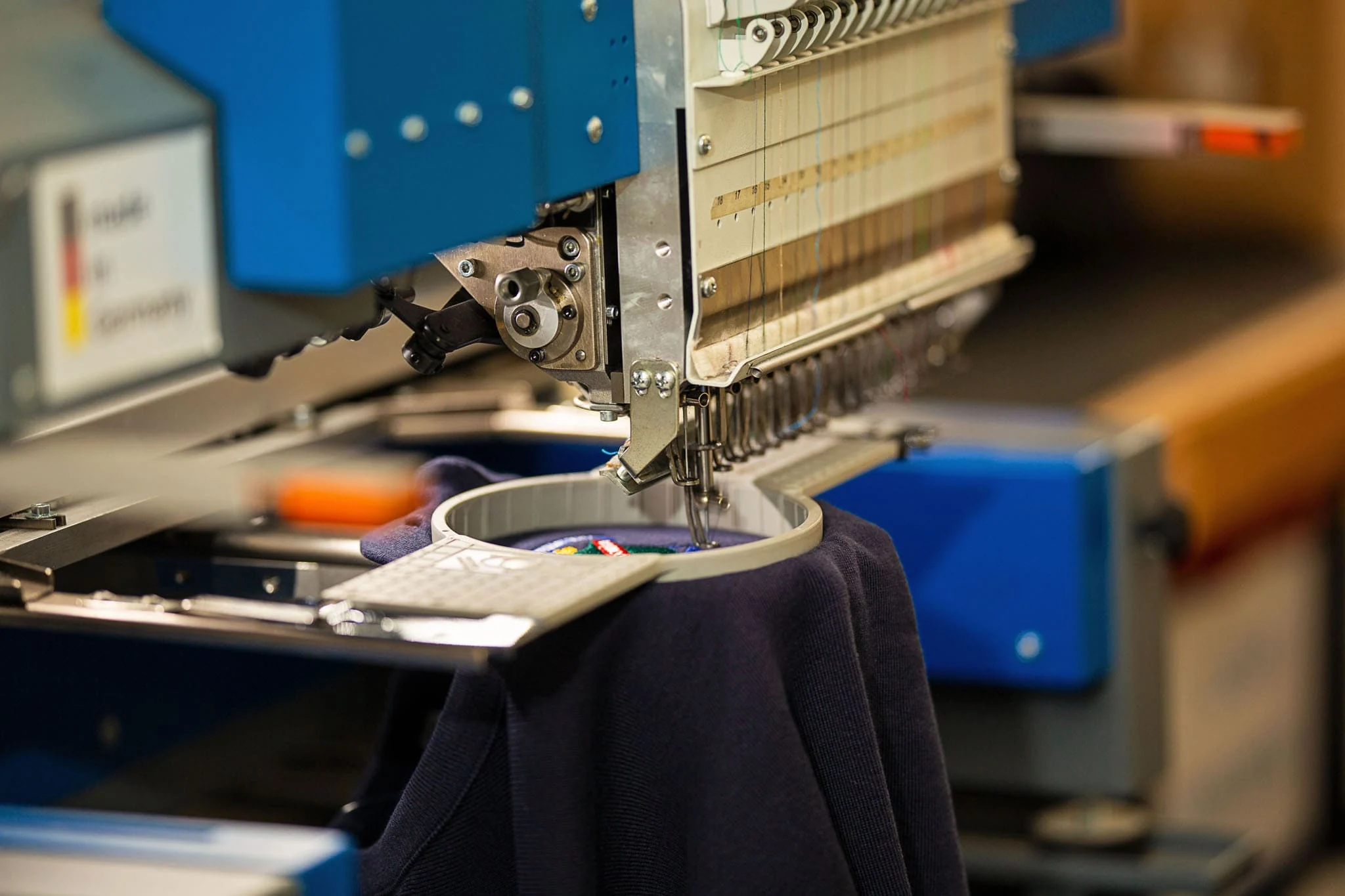 Multi-head embroidery machine stitching a logo in the ALE workshop